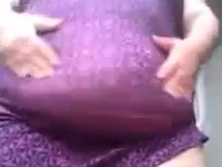 SSBBW in a purple dress plays with her large belly